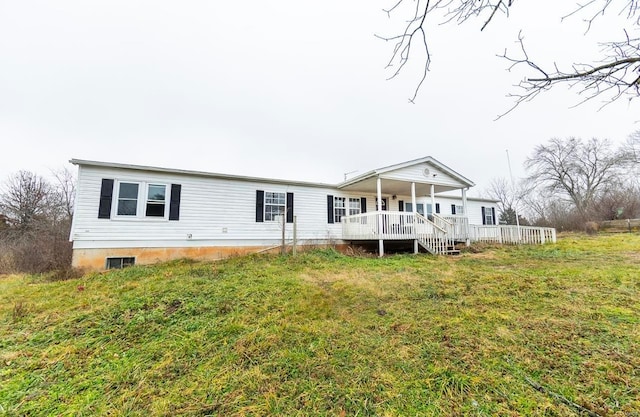 back of property with covered porch and a lawn