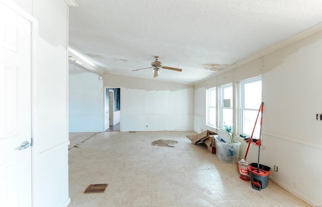 misc room featuring ceiling fan and a textured ceiling