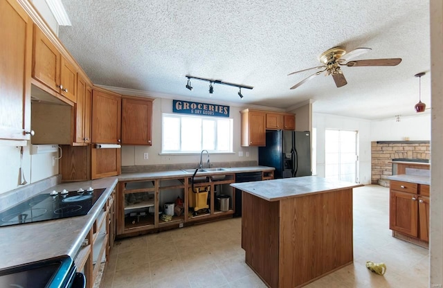 kitchen featuring ceiling fan, a center island, black appliances, sink, and rail lighting