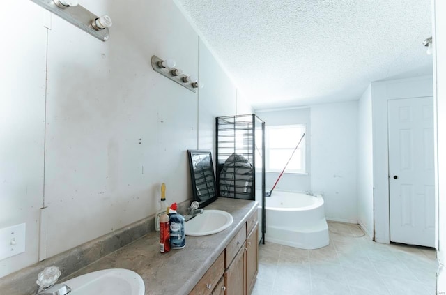 bathroom with vanity, a washtub, and a textured ceiling