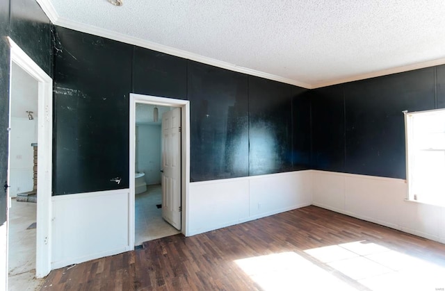 unfurnished room with wood-type flooring, ornamental molding, and a textured ceiling