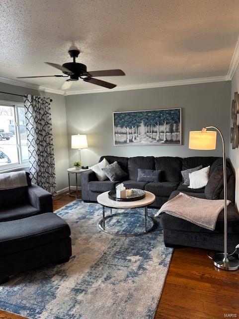 living room featuring ceiling fan, crown molding, dark wood-type flooring, and a textured ceiling