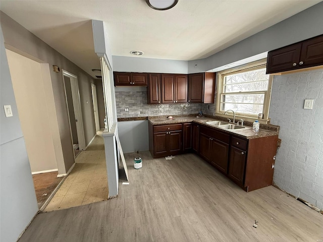 kitchen with dark brown cabinetry, light hardwood / wood-style floors, and sink