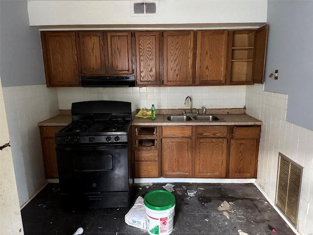 kitchen featuring black gas range, backsplash, and sink