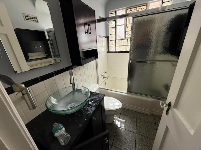 full bathroom with toilet, shower / bath combination with glass door, decorative backsplash, vanity, and tile walls