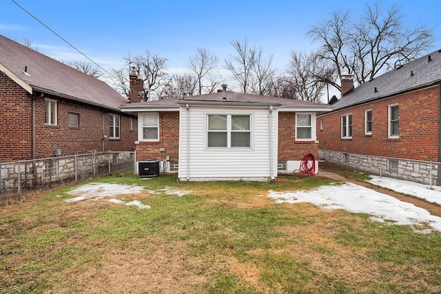 back of house with central AC unit and a lawn