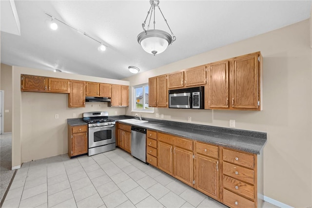 kitchen featuring sink, vaulted ceiling, light tile patterned floors, decorative light fixtures, and stainless steel appliances