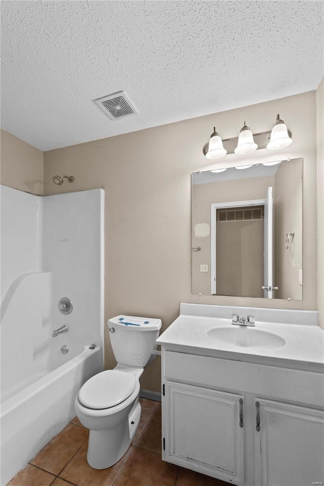 full bathroom with shower / bathing tub combination, vanity, tile patterned floors, toilet, and a textured ceiling