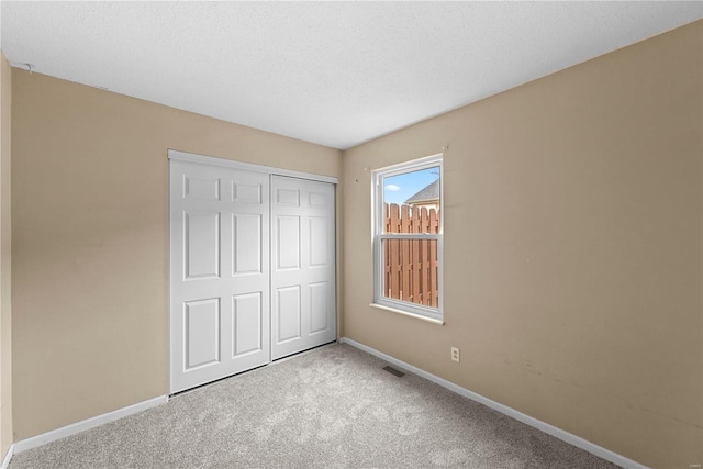 unfurnished bedroom featuring carpet floors and a closet