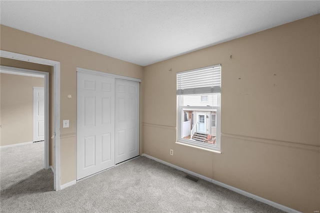 unfurnished bedroom with light carpet and a closet