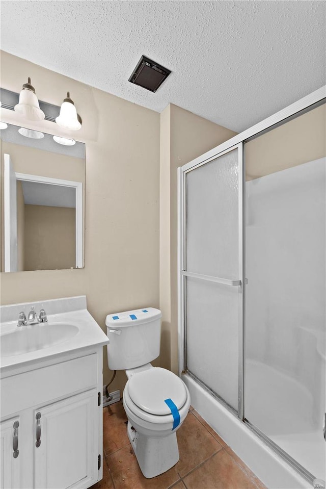 bathroom featuring tile patterned flooring, vanity, an enclosed shower, and a textured ceiling