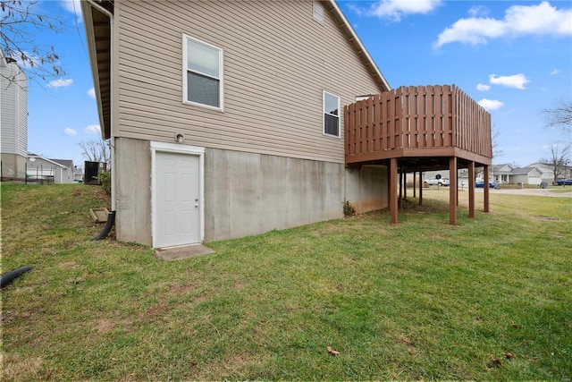 back of house featuring a lawn and a wooden deck