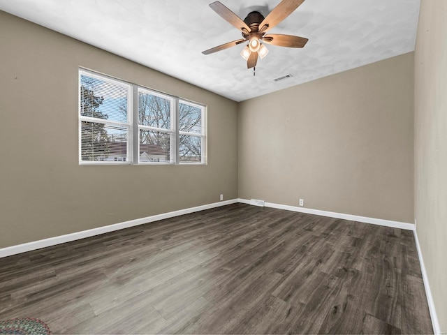 empty room with ceiling fan and dark hardwood / wood-style flooring