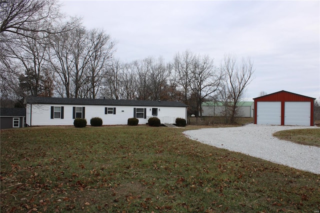 view of front of house with a garage, an outbuilding, and a front lawn