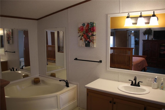 bathroom with a bathing tub, crown molding, vanity, and toilet