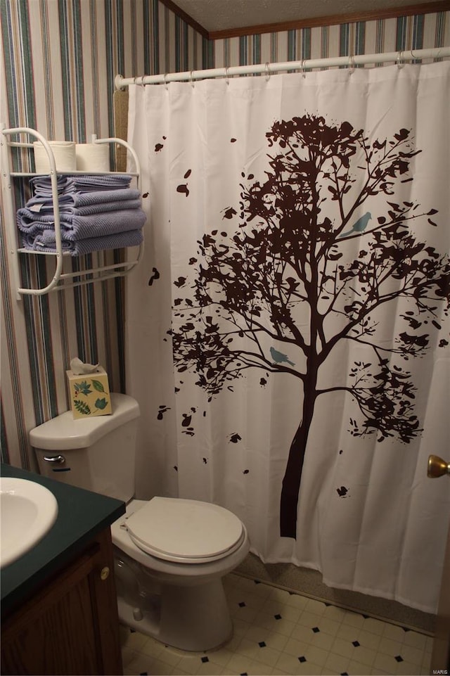 bathroom featuring vanity, toilet, ornamental molding, and a textured ceiling