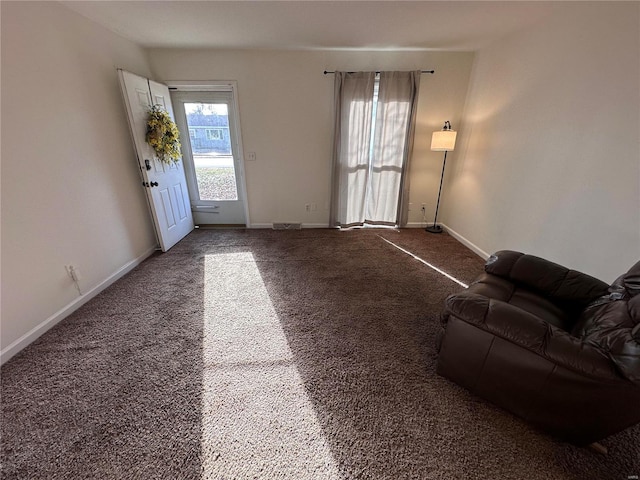 unfurnished living room featuring carpet flooring and baseboards