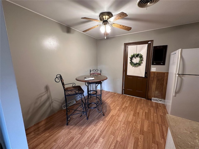 dining space with a ceiling fan, visible vents, and light wood finished floors