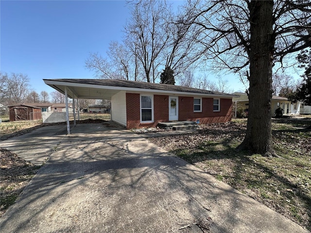 view of front of house with brick siding, driveway, and a carport