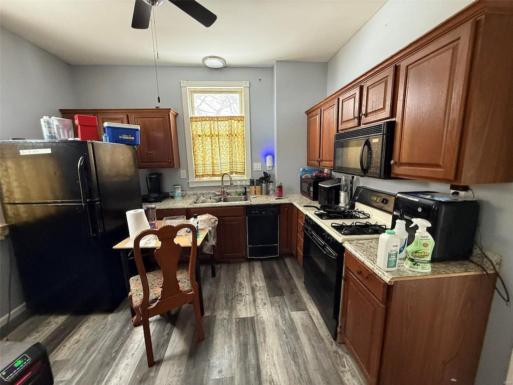 kitchen featuring black appliances, dark hardwood / wood-style floors, ceiling fan, and sink