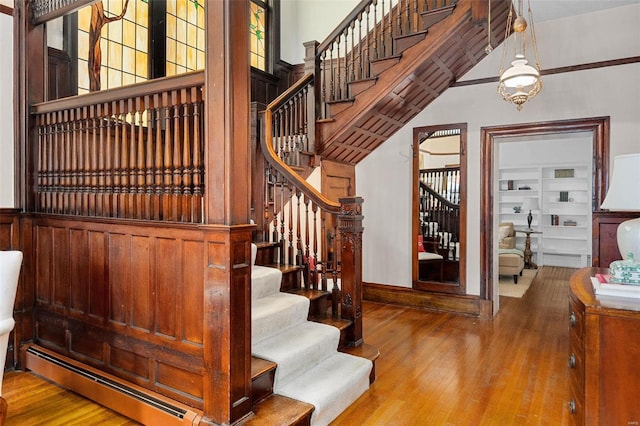 staircase with baseboard heating and wood-type flooring