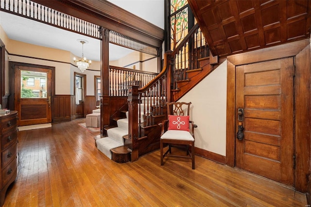 staircase featuring wood ceiling, hardwood / wood-style floors, and a chandelier