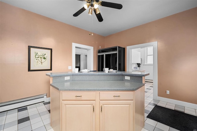 kitchen featuring light tile patterned floors, black fridge, ceiling fan, and a baseboard heating unit