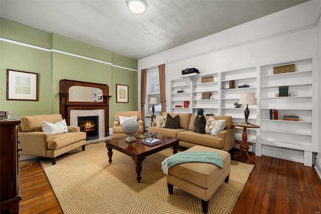 sitting room featuring a tile fireplace, dark hardwood / wood-style flooring, and a textured ceiling