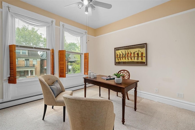 office space with ceiling fan, a healthy amount of sunlight, and a baseboard heating unit