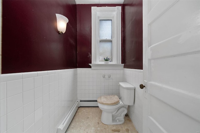 bathroom featuring a baseboard radiator, toilet, and tile walls