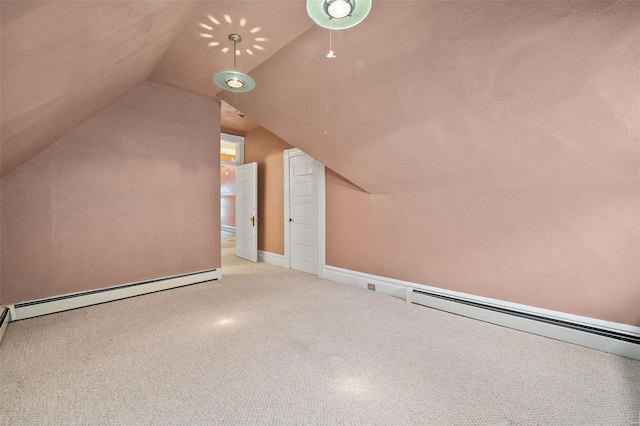 additional living space featuring vaulted ceiling and a baseboard heating unit