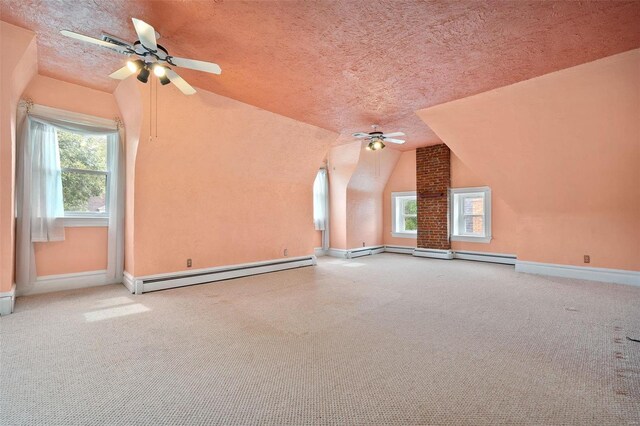 bonus room with a textured ceiling, ceiling fan, baseboard heating, and vaulted ceiling