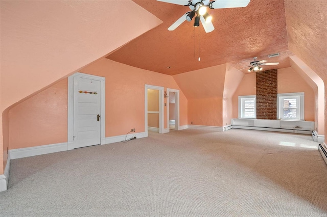 additional living space featuring lofted ceiling, ceiling fan, a textured ceiling, a baseboard radiator, and carpet floors