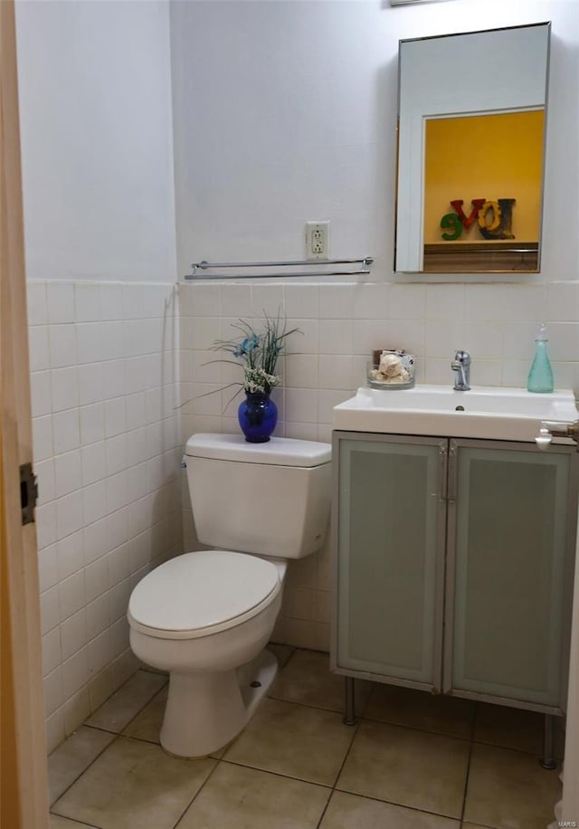 bathroom featuring toilet, tile patterned flooring, tile walls, and vanity