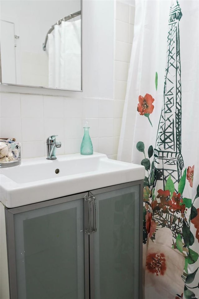 bathroom with vanity, decorative backsplash, and tile walls