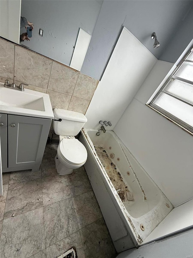 bathroom featuring a washtub, toilet, tile walls, and vanity