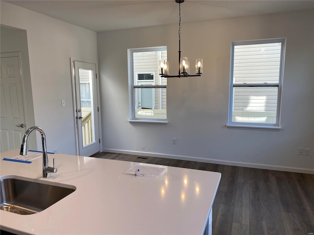 kitchen featuring a chandelier, pendant lighting, dark wood-type flooring, and sink