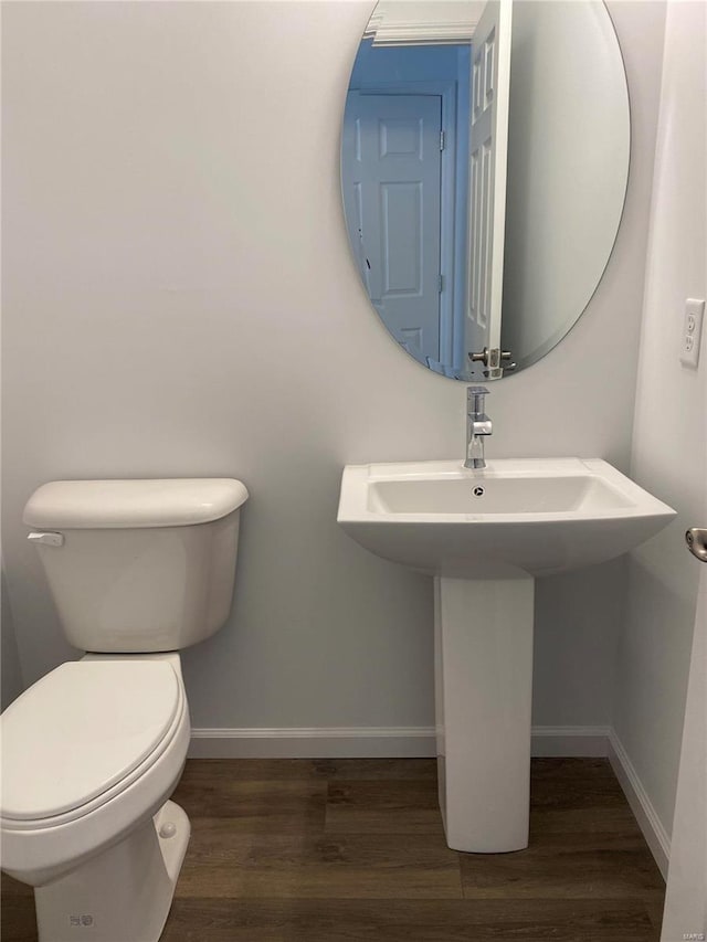 bathroom with hardwood / wood-style flooring, toilet, and sink