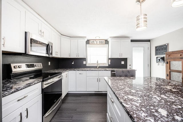 kitchen with backsplash, white cabinetry, stainless steel appliances, and a sink