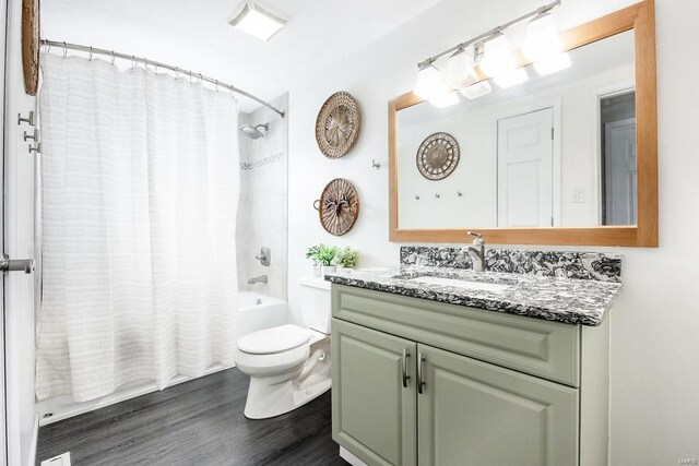 bathroom featuring toilet, wood finished floors, vanity, and shower / bath combination with curtain