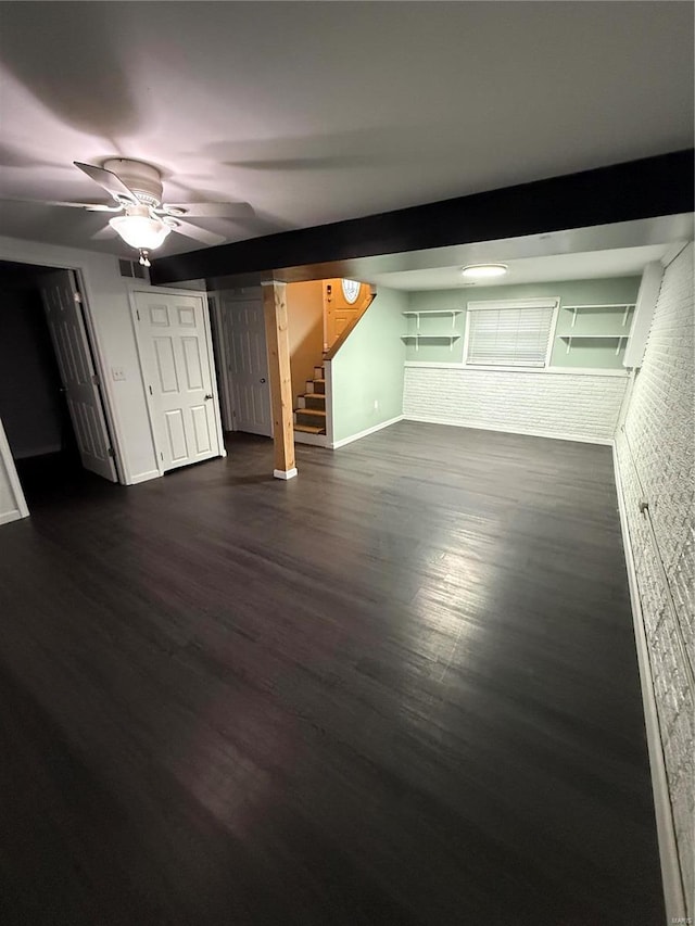 interior space featuring dark wood-style floors, visible vents, baseboards, a ceiling fan, and stairs