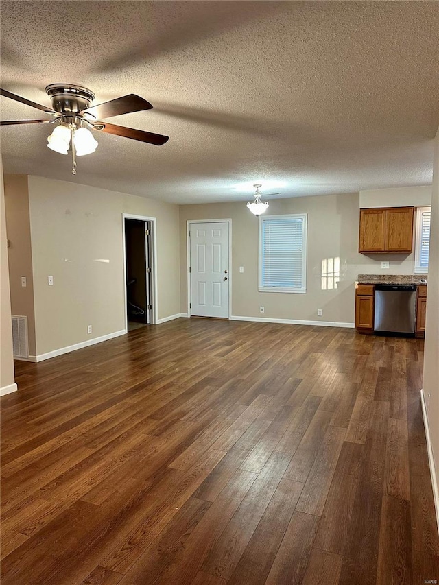 unfurnished living room featuring ceiling fan, dark hardwood / wood-style flooring, and a textured ceiling