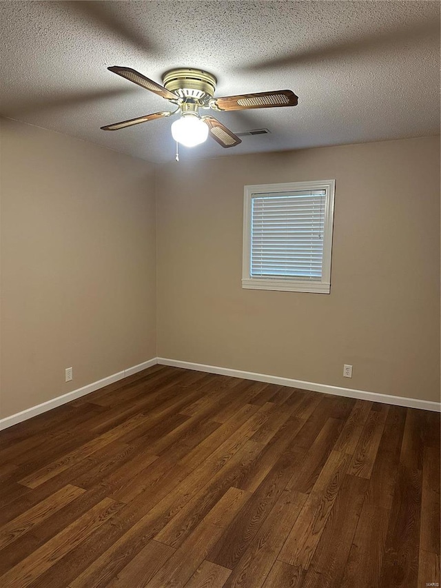 empty room featuring a textured ceiling, dark hardwood / wood-style floors, and ceiling fan