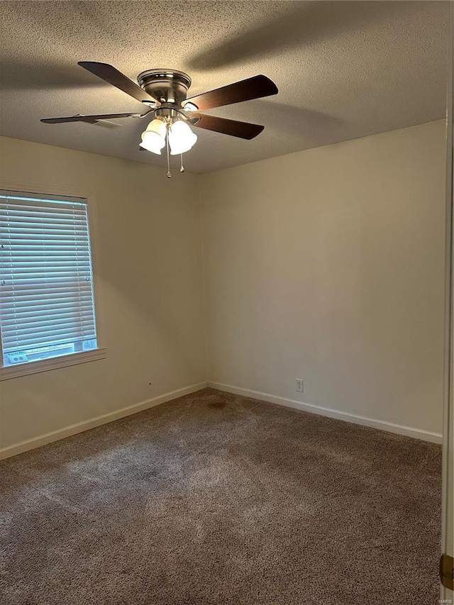 carpeted empty room with ceiling fan and a textured ceiling