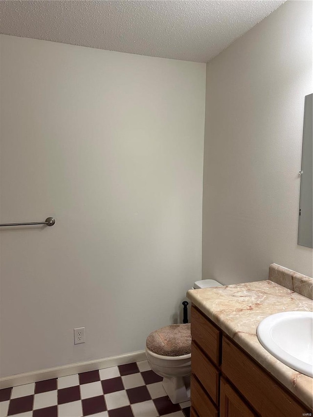 bathroom featuring a textured ceiling, vanity, and toilet