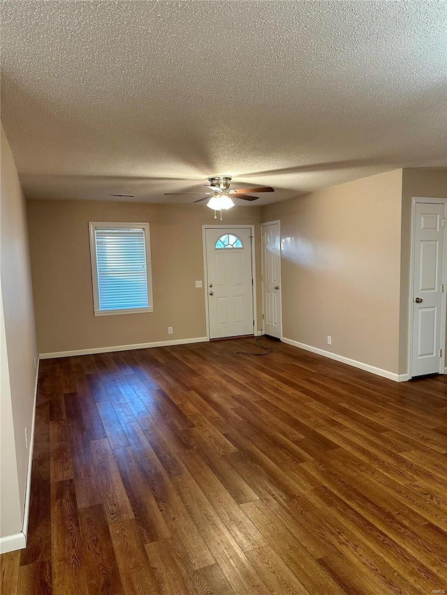 foyer entrance with ceiling fan, dark hardwood / wood-style flooring, and a textured ceiling