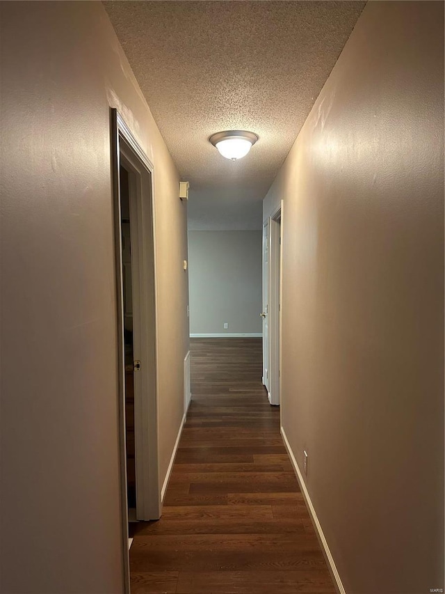 hall featuring dark hardwood / wood-style flooring and a textured ceiling