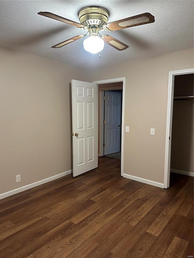 unfurnished bedroom with dark hardwood / wood-style flooring, a textured ceiling, a closet, and ceiling fan