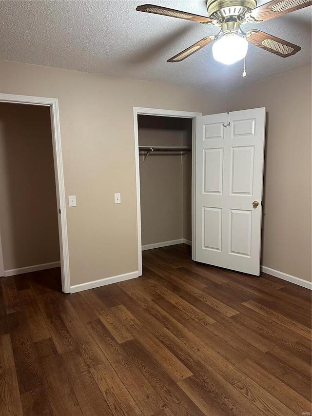 unfurnished bedroom with ceiling fan, a closet, dark hardwood / wood-style floors, and a textured ceiling