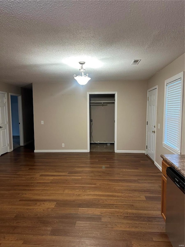 unfurnished room featuring a textured ceiling and dark wood-type flooring